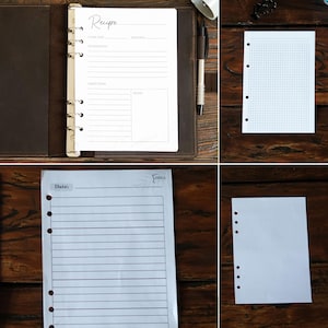 May include: A collection of white paper inserts for a binder, including recipe pages, graph paper, lined paper, and dotted paper. The recipe page has the word "Recipe" at the top. A brown leather binder and a pen are also visible.