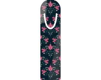 May include: A decorative bookmark with a floral pattern. The bookmark features a dark blue background with a repeating design of pink flowers and green leaves. The top has a curved shape with a white cutout for the page.