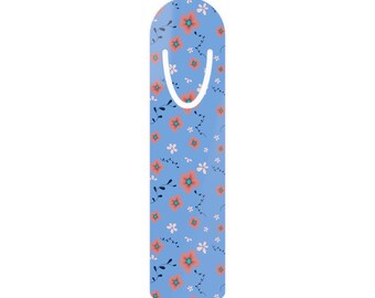 May include: A floral bookmark with a light blue background. The bookmark features a pattern of orange and white flowers with green stems and leaves. A white curved cutout is at the top for easy placement in a book.