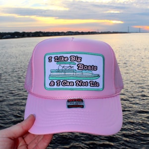 May include: Pink trucker hat with a green and white embroidered patch that says "I Like Big Boats & I Can Not Lie".