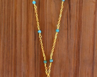 Collar de hojas de monstera con cuentas azules y doradas