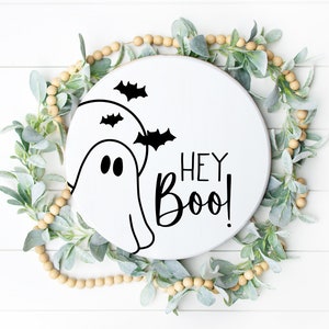 May include: White round wooden sign with a black ghost and bats, and the text "Hey Boo!" in black lettering.