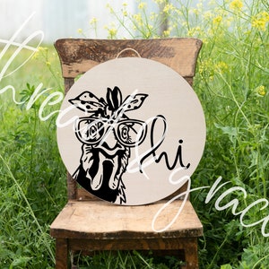 May include: A circular, light beige wooden sign with a black and white illustration of a chicken wearing glasses and a bandana. The sign has the words "Hi" and "Grace" in a script font. A jute rope is attached for hanging.