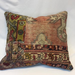 May include: A rectangular pillow with a patchwork design. The pillow features various sections of patterned fabric in shades of red, beige, green, and brown. The patterns include floral and geometric motifs, creating a vintage or bohemian aesthetic.