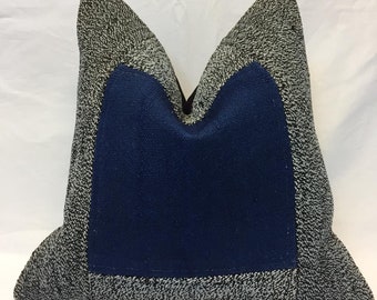 Puede incluir: Una almohada decorativa con una tela estampada en blanco y negro y un inserto de tela azul. La almohada tiene la forma de una almohada tradicional con una parte superior puntiaguda y una parte inferior plana.