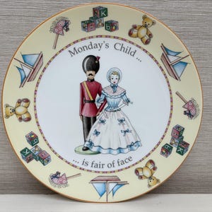 Könnte beinhalten: Ein weißer Keramikteller mit gelbem Rand und einem bunten Design aus Spielzeug, einem Mädchen und einem Jungen in Militäruniform. Der Teller sagt "Monday's Child... is fair of face".