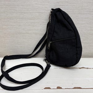 May include: Black sling bag with a zippered main compartment and an adjustable shoulder strap. The bag is made of a durable, lightweight material and features a sleek, minimalist design. Ideal for carrying essentials.