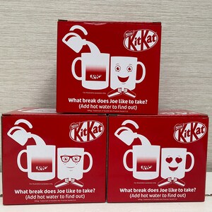 May include: Three red boxes with a white KitKat logo and a white mug on each box. The mugs have different designs: a plain mug, a mug with glasses and a mug with a smiley face. The text on the boxes reads: "What break does Joe like to take? (Add hot water to find out)"