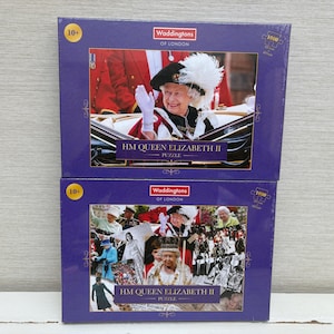 Könnte beinhalten: Zwei 1000-teilige Puzzles mit Bildern von Königin Elisabeth II. Das obere Puzzle zeigt die Königin in einer Kutsche, während das untere Puzzle eine Collage von Bildern der Königin während ihrer Regierungszeit zeigt. Beide Puzzles sind von Waddingtons of London.