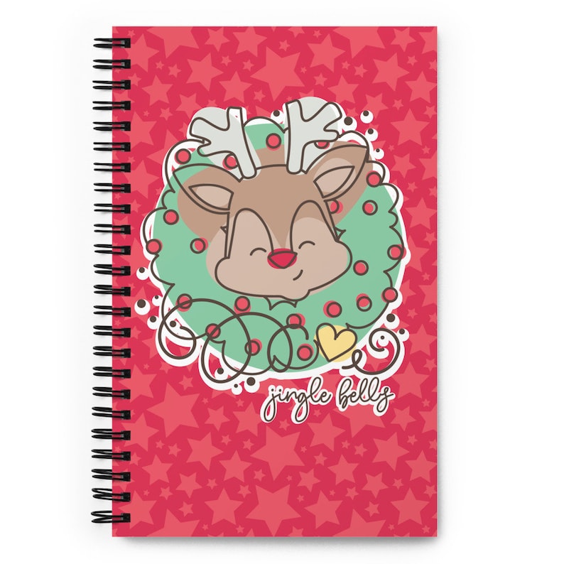 May include: A red spiral notebook with a cute cartoon reindeer wearing a green wreath with red berries and the text "jingle bells". The background is a red pattern of white stars.