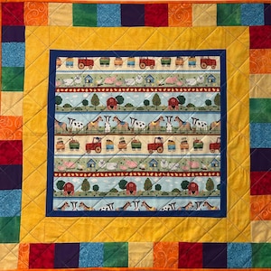 May include: A quilted farm-themed blanket with a colorful patchwork border. The central panel features repeating rows of farm animals, tractors, and barns on a light blue background. The border is a mix of yellow, orange, red, green, and blue squares.