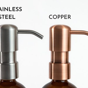 Puede incluir: Primer plano de siete botellas de bomba de jab&oacute;n de diferentes colores. Las botellas son todas de la misma forma y tama&ntilde;o, pero tienen tapas de diferentes colores. Los colores son negro mate, blanco mate, acero inoxidable, cobre, oro y lat&oacute;n.