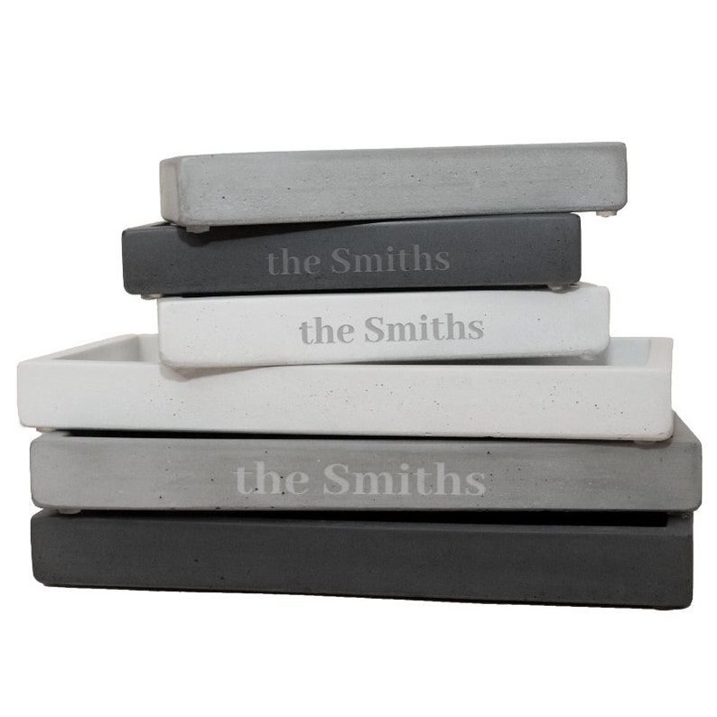 Peut inclure: Une pile de quatre plateaux en b&eacute;ton gris avec les mots "the Smiths" grav&eacute;s sur chaque plateau.