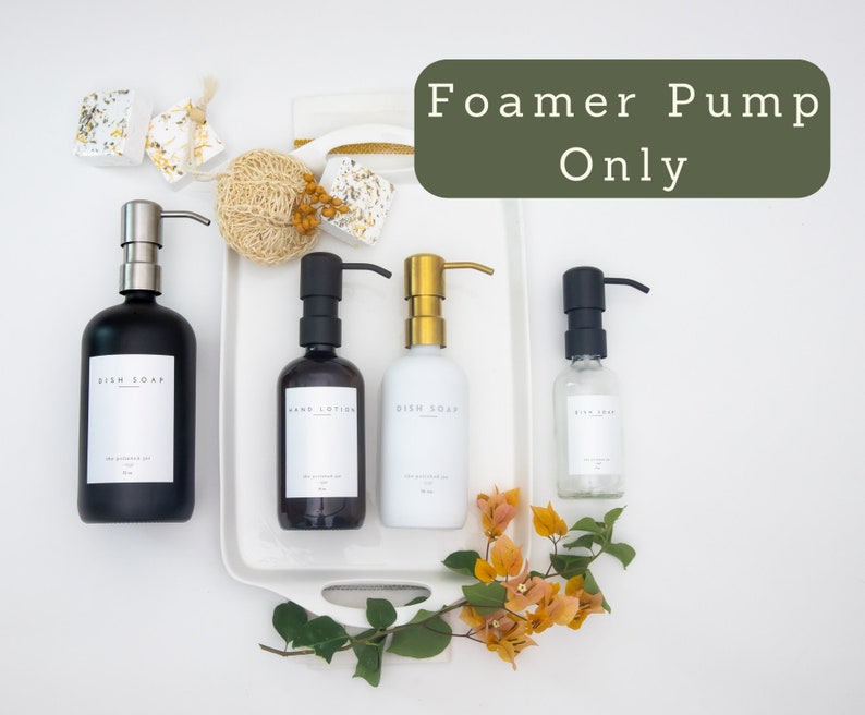 Puede incluir: Cuatro botellas de vidrio negro, blanco y transparente con etiquetas que dicen "Jab&oacute;n para platos" y "Loci&oacute;n para manos". Las botellas tienen bombas de espuma negras, doradas y plateadas. El texto "Foamer Pump Only" est&aacute; escrito en verde sobre un fondo blanco.