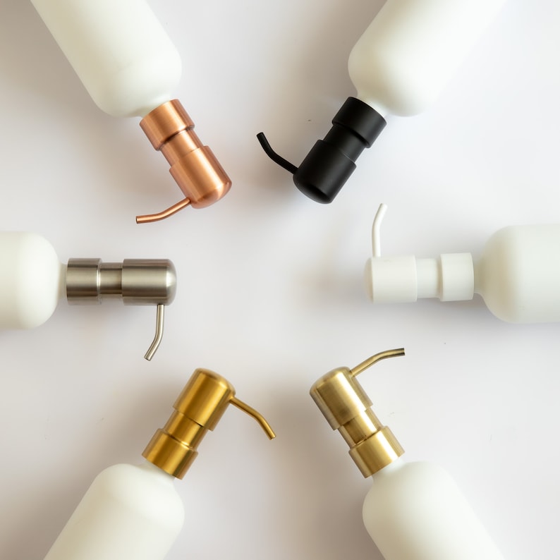 Puede incluir: Cinco dispensadores de jab&oacute;n de cer&aacute;mica blanca con bombas de diferentes colores. Las bombas son doradas, plateadas, negras, cobre y oro rosa.