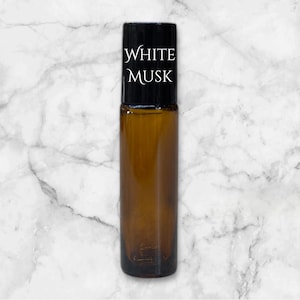 May include: A brown glass roller bottle with a black lid and a white label that says "WHITE MUSK".