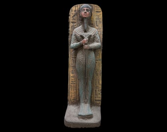 May include: A standing statue of an Egyptian deity with a blue and gold paint scheme. The statue is carved from stone and has hieroglyphics on the back.