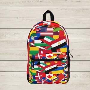 May include: A black backpack with a colourful pattern of flags from around the world. The backpack has two zipped pockets on the front.