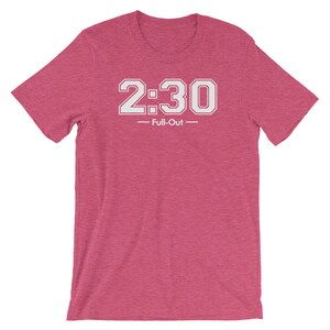 Peut inclure: T-shirt rose &agrave; manches courtes avec l'inscription blanche "2:30 - Full-Out". Le texte est en gras, avec des chiffres soulign&eacute;s. Le t-shirt a un col rond et une texture chin&eacute;e.