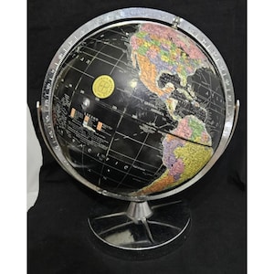 May include: A black globe with colorful continents and a silver metal stand. The globe has a silver meridian ring and a degree scale. The continents are in shades of green, yellow, orange, and purple.
