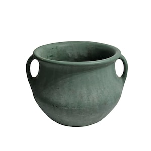 May include: A green ceramic pot with two handles. The pot has a rounded shape and a textured surface.