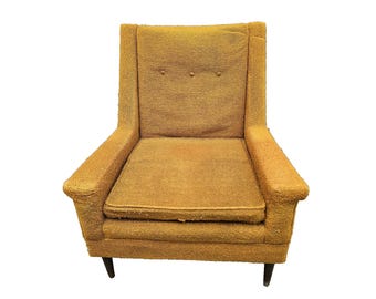 May include: A vintage, mustard-yellow armchair with a high back and armrests. The chair features a textured fabric, three button details on the backrest, and dark wooden legs. A classic piece of mid-century modern furniture.
