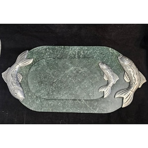 May include: A green marble serving tray with two silver fish handles. The tray is oval shaped and has a raised edge.