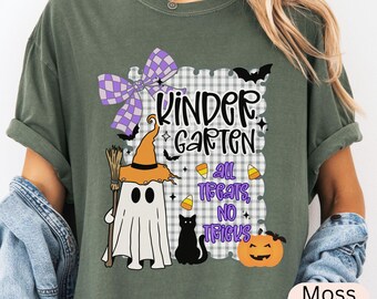 May include: Moss green t-shirt with a Halloween-themed graphic. The design features a ghost wearing a witch hat, a black cat, a pumpkin, and the text "Kindergarten All Treats, No Tricks". A purple bow and bats complete the design.
