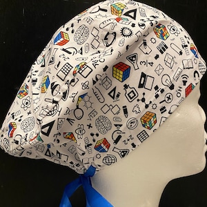 May include: White scrub hat with a blue tie. The hat is covered in a pattern of colourful science and maths symbols, including a brain, a light bulb, a ruler, a calculator, a beaker, a microscope, and a Rubik's cube.
