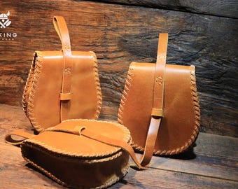 May include: Three brown leather bags with a braided trim. The bags have a flap closure and a long strap.