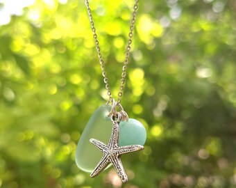 May include: A silver chain necklace with a light blue sea glass pendant and a silver starfish charm.