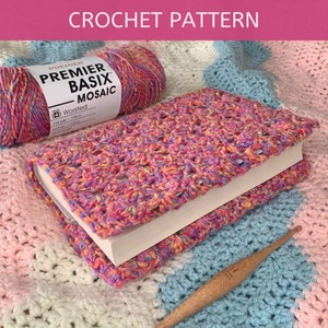 May include: A crochet book cover made with a multi-coloured yarn in shades of pink, yellow, and blue. The yarn is labelled "Premier Basix Mosaic Worsted 216 yds - 198 m".