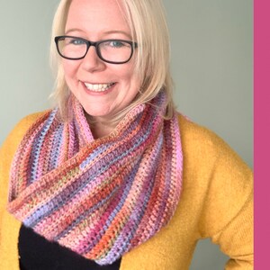 May include: A colourful crochet infinity scarf with stripes of pink, purple, orange and red.
