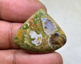 May include: A green, brown, and white agate cabochon with a unique pattern. The stone is cut in a teardrop shape and has a smooth, polished surface.