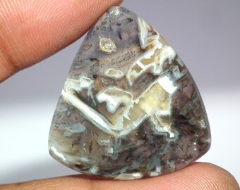 May include: A triangular, translucent, grey agate cabochon with white and brown patterns. The agate has a polished surface and is a natural gemstone.