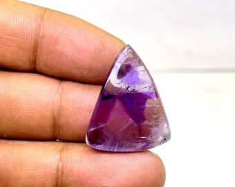May include: A triangular amethyst gemstone with a purple and white color pattern. The gemstone is cut and polished.