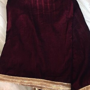 May include: A burgundy velvet shawl with a gold embroidered border.