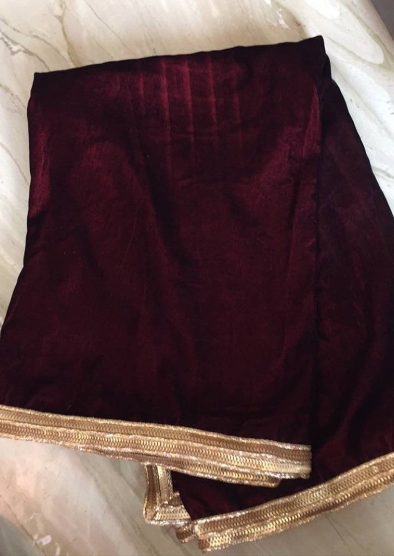 May include: A burgundy velvet shawl with a gold embroidered border.