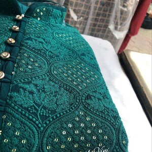 Puede incluir: Una kurta azul turquesa con bordados dorados y lentejuelas. La kurta tiene un cuello mandar&iacute;n y cierre de botones. La tela es una gasa ligera.