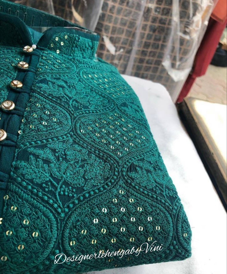 Puede incluir: Una kurta azul turquesa con bordados dorados y lentejuelas. La kurta tiene un cuello mandar&iacute;n y cierre de botones. La tela es una gasa ligera.