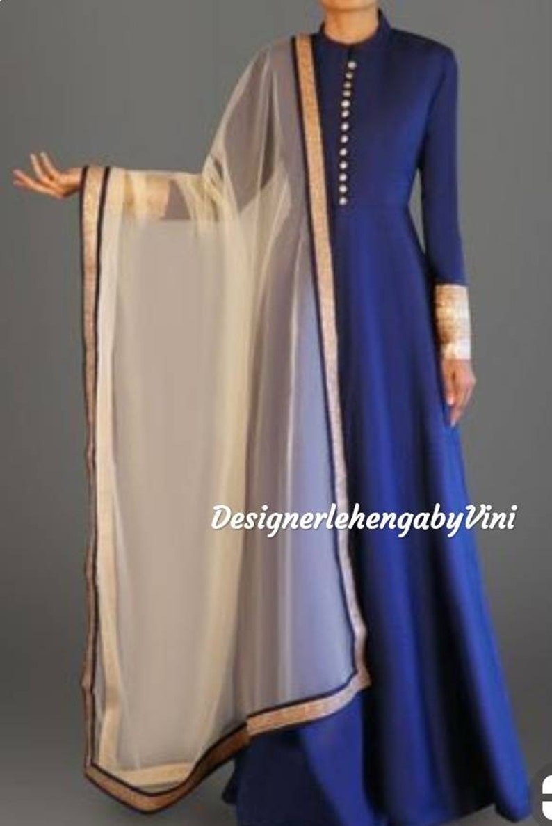 May include: A royal blue long-sleeved dress with a high neckline and a row of gold buttons. The dress has a flared skirt and is paired with a sheer white dupatta with a gold and black border.