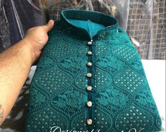 May include: A teal blue kurta with a button-up front and intricate embroidery. The kurta has a high neckline and is decorated with small, silver-colored sequins.