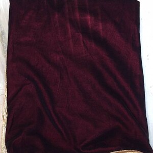 May include: A burgundy velvet shawl with a gold embroidered border.
