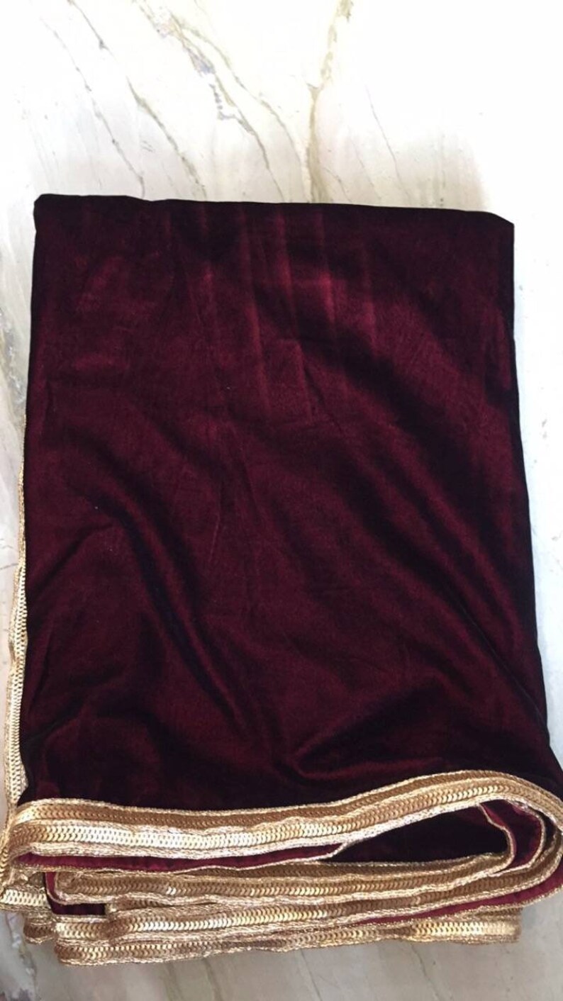 May include: A burgundy velvet shawl with a gold embroidered border.