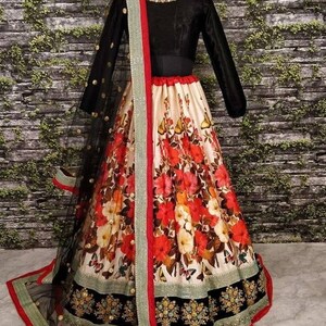 Pu&ograve; includere: Un lehenga con stampa floreale bianca e rossa con un bordo ricamato nero. Il lehenga &egrave; abbinato a una blusa nera a maniche lunghe e a un dupatta in rete nera con un bordo rosso.