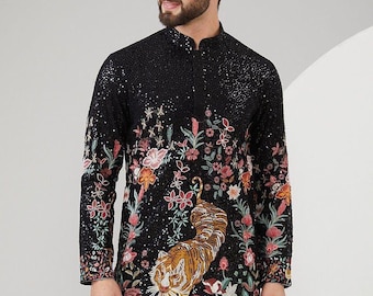 May include: A black long-sleeved shirt with a floral and tiger print. The shirt has a mandarin collar and a button closure. The text "DLV" is visible on the bottom right corner of the shirt.