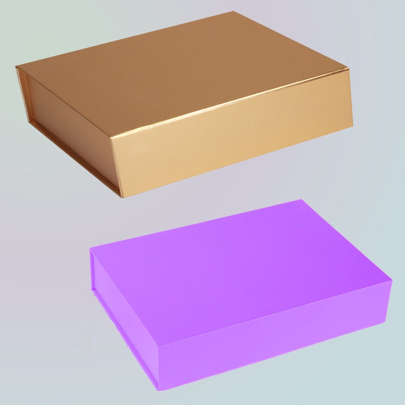 May include: Two rectangular gift boxes. One is gold, with a metallic sheen. The other is a solid purple. Both boxes have a magnetic closure and are designed for packaging gifts or retail items. The boxes are empty.