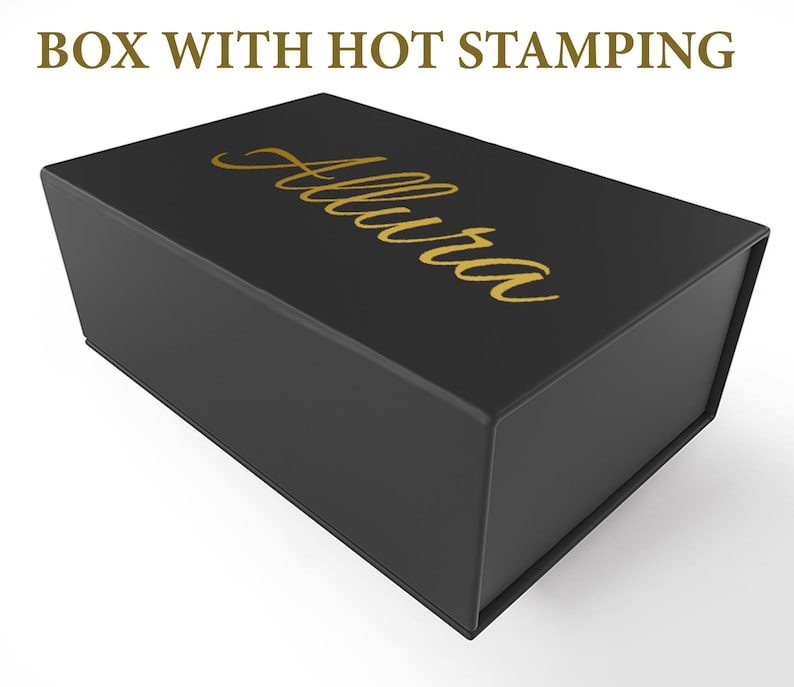 May include: A black rectangular box with a hinged lid. The box has gold lettering that reads "Allura" on the top. The text "BOX WITH HOT STAMPING" is above the box.