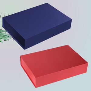 May include: Two rectangular gift boxes. One is a deep navy blue, and the other is a vibrant red. Both boxes have a matte finish and a magnetic closure. The boxes are empty and ready to be filled with gifts.