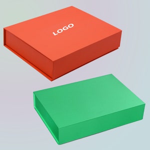 May include: Two rectangular boxes, one orange and one green, are displayed. The orange box has a white "LOGO" printed on the top. Both boxes have a magnetic closure. The boxes are likely for packaging or storage.